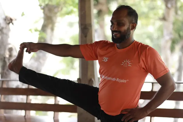 Abhilash Soman holding an extended standing pose in the open-sided studio.