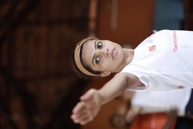 A student reaching into a seated twist, photographed close.