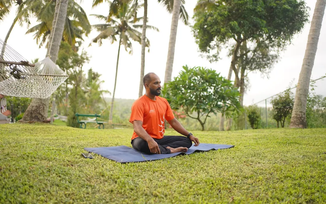 A student sitting in meditation on the lawn at the Visramam retreat.